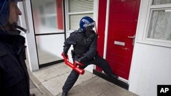 Police officers raid a property in Pimlico, London, August 12, 2011