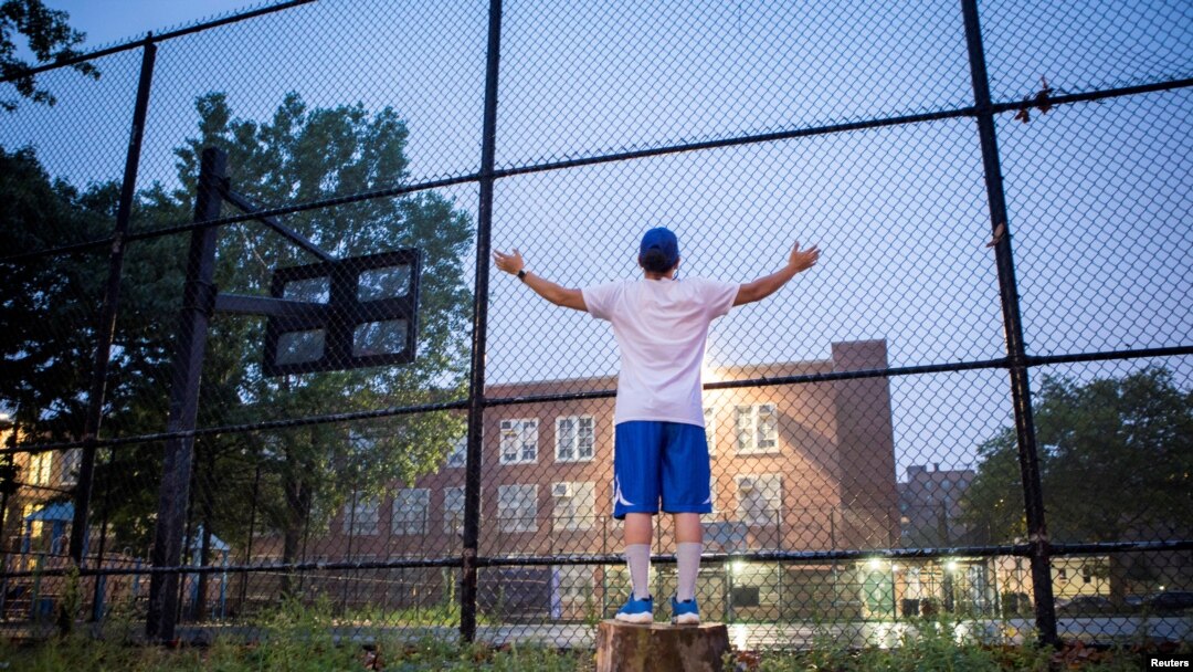 Emily Rodriguez says a prayer in front of Castle Hill Playground in the Bronx, ahead of the planned reopening of schools amid the coronavirus outbreak, in New York, Sept. 2, 2020.