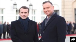 President Emmanuel Macron,left, of France and his Polish host, President Andrzej Duda, shake hands before talks on developing recently-strained bilateral ties at the Presidential Palace in Warsaw, Poland, Feb. 3, 2020.