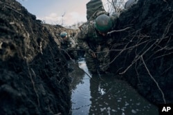 Tentara Ukraina terlihat bersembunyi di parit di tengah serangan Rusia di dekat Bakhmut, wilayah Donetsk, Ukraina, Minggu, 5 Maret 2023.(Foto: AP)
