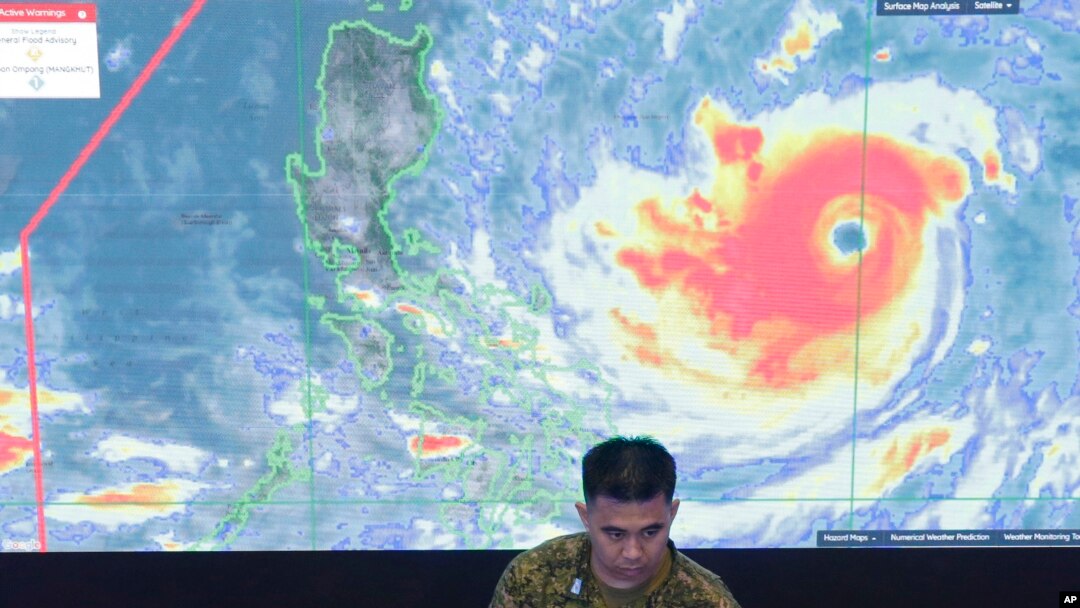 Seorang anggota Angkatan Udara Filipina berdiri di depan citra satelit Typhoon Mangkhut, yang disebut Typhoon Ompong oleh warga setempat, di pusat operasi Dewan Manajemen dan Penanggulangan di Manila, Filipina, Kamis, 13 September 2018.
