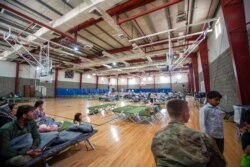 Evacuees rest at a gym in an undisclosed Middle East location, Aug. 20, 2021, after being flown out aboard a military aircraft from Hamid Karzai International Airport in Kabul, Afghanistan. (Airman 1st Class Kylie Barrow, U.S. Air Force via AP)