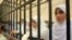 Egyptian women supporters of ousted President Mohamed Morsi stand inside the defendants' cage in a courtroom in Alexandria, Egypt, Nov. 27, 2013. 