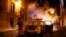 Un sapeur-pompier essaie d'éteindre le feu sur une voiture incendiée sur les Champs-Elysées après la défaite du PSG, France, le 23 août 2020. 