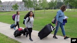 First generation college student Minori Kawano, of New York, center, arrives at Middlebury College accompanied by her mother, Mercy Kawano, right, and younger sister Mayomi Kawano, left. The school is among a number of colleges with programs to help ease the transition to college for students who are the first in their families to attend. (AP Photo/Wilson Ring)