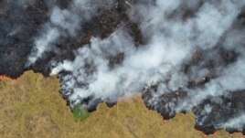 FILE - Smoke rises over a deforested plot of the Amazon jungle in Porto Velho, Rondonia State, Brazil, Aug. 24, 2019.