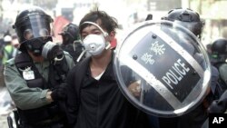 Police officers detain a protester near the Hong Kong Polytechnic University in Hong Kong, Monday, Nov. 18, 2019. Hong Kong police have swooped in with tear gas and batons as protesters who have taken over a university campus make an apparent last…