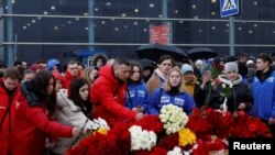 Personas depositan flores en las afueras de la sala de conciertos Crocus City Hall, en un monumento improvisado a las víctimas del ataque a tiros que dejó más de un centenar de muertos. Foto del 24 de marzo de 2024.