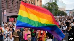 Učesnik maše velikom zastavom duginih boja tokom godišnje LGBT Parade ponosa u Beogradu, Srbija, u subotu, 18. septembra 2021. (AP Photo/Darko Vojinovic)