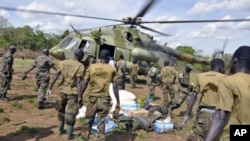 Ugandan soldiers, who are tracking down Lord's Resistance Army (LRA) fugitive leaders, load supplies off a military helicopter in a forest bordering Central African Republic, South Sudan and Democratic Republic of Congo, near river Chinko, April 18, 2012.