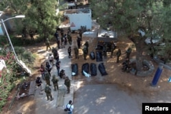 FILE - An aerial view shows the bodies of victims of an attack following a mass infiltration by Hamas gunmen from the Gaza Strip, lie on the ground in Kibbutz Kfar Aza, in southern Israel, October 10, 2023.