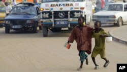 FILE - Two students beg to meet the daily quota imposed by their teacher in a neighborhood of Dakar, Senegal, Aug. 31, 2010. A mobile videogame was created to raise awareness of the tens of thousands of children in Senegal who are forced to beg in the streets by teachers at Koranic schools.