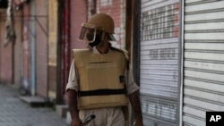 A Kashmiri policeman guards a closed shop in Srinagar, Indian-controlled Kashmir, Aug. 22, 2019. 