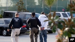 Immigration and Customs Enforcement agents take a suspect into custody as part of a nationwide immigration sweep in Chula Vista, California, March 30, 2012.