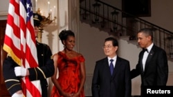 2011년 1월 19일 미국 워싱턴 백악관에서 열린 국빈 만찬에 참석한 버락 오바마 미국 대통령과 미셸 오바마 여사가 후진타오 중국 국가주석을 맞이하고 있다.