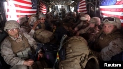 FILE - U.S. Marines are seen on board a helicopter at Kandahar air base upon the end of operations for the Marines and British combat troops in Helmand province, Oct. 27, 2014. 