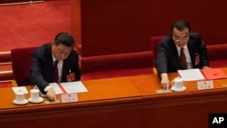 ប្រធានាធិបតីចិនលោក Xi Jinping និងនាយករដ្ឋមន្ត្រីចិនលោក Li Keqiang បោះឆ្នោតក្នុងសមាជប្រជាជាតិ នៅវិមានរដ្ឋាភិបាលចិន ក្នុងទីក្រុងប៉េកាំង ប្រទេសចិន កាលពីថ្ងៃទី១១ ខែមីនា ឆ្នាំ២០២១។