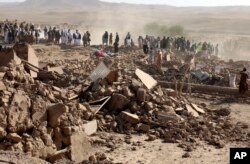 Sejumlah pria Afghanistan mencari korban setelah gempa bumi di distrik Zenda Jan di Provinsi Herat, Afghanistan barat, Minggu, 8 Oktober 2023. (Foto: AP)