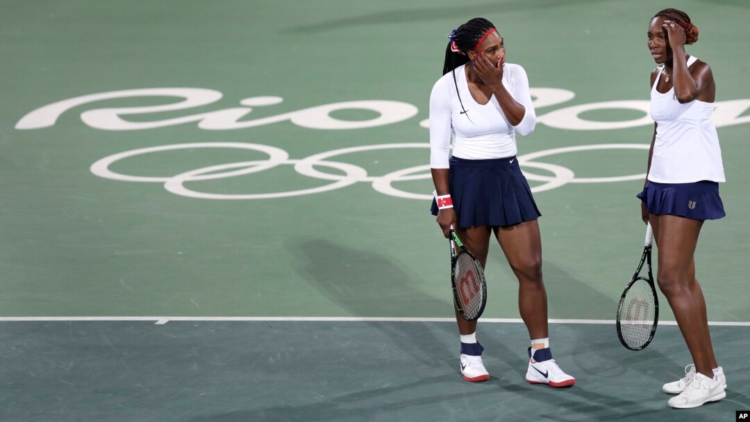Venus Williams (kanan) dan adiknya Serena dalam pertandingan ganda tenis putri di Olimpiade Rio de Janeiro 2016. (AP/Charles Krupa)