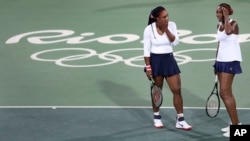 Venus Williams (kanan) dan adiknya Serena dalam pertandingan ganda tenis putri di Olimpiade Rio de Janeiro 2016. (AP/Charles Krupa)