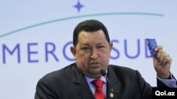 El presidente de Venezuela, Hugo Chávez, enseña una copia de su constitución venezolana al dirigirse a la prensa durante la Cumbre Extraordinaria de Mercosur que se realiza en Brasil.