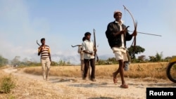 Tribal plantation workers armed with tools for self-defence move to a safer place after ethnic clashes in Tenganala village in Sonitpur district, in the northeastern Indian state of Assam, December 24, 2014.