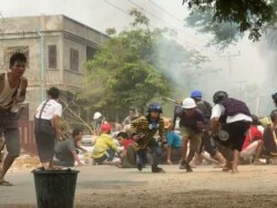 Protesters take cover during clashes with security forces in Monywa, Myanmar, March 21, 2021, in this still image from a video obtained by Reuters.
