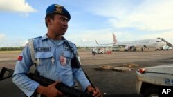 Seorang personel angkatan udara berjaga-jaga dekat pesawat Virgin Australia di Bali, Indonesia (25/4). (AP/Firdia Lisnawati)