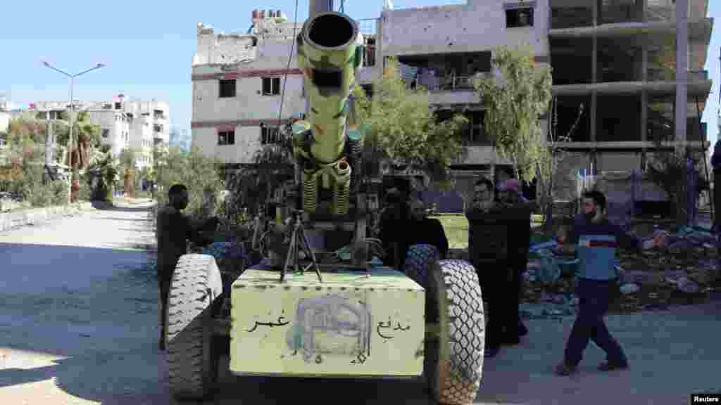 Free Syrian Army fighters prepare to fire an artillery cannon towards forces loyal to Syria's President Bashar al-Assad in the eastern Damascus suburb of Ghouta, March 23, 2014. 