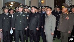 North Korean leader Kim Jong Il, in light gray, and his son Kim Jong Un, center, look at a gift from Gen. Guo Boxiong, vice chairman of China's Central Military Commission, second left in front, in Pyongyang, North Korea, Oct 25, 2010 (file photo)