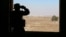 A rebel fighter looks through binoculars in Quneitra countryside, Syria, Sept. 10, 2016.