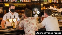 Customers sit at a bar on the first day of reopening in Auckland, New Zealand, on Dec. 3, 2021, as the country revamps its domestic COVID-19 response.