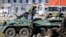 Armed men, believed to be Russian servicemen, supply an armored personnel carrier (APC) in front of a Ukrainian marine base in the Crimean port city of Feodosia March 23, 2014.