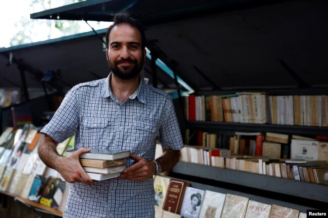 Newly Parisian bouquiniste, traditional street bookseller, Rachid Bouanou poses during an interview with Reuters, along the banks of the River Seine in Paris, France, August 18, 2022. REUTERS/Sarah Meyssonnier