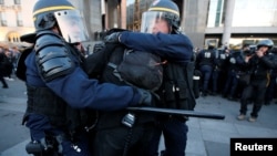 Des CRS arrêtent des protestants dans les rues de Paris, le 23 avril 2017.