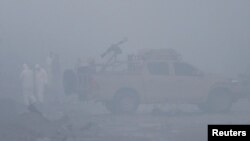 FILE - Afghan security officials investigate the site of a car bomb attack in Kabul, Afghanistan, Nov. 29, 2018. A similar attack hit a security convoy in Kabul Tuesday.