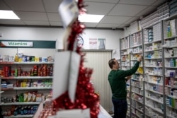 FILE - Pharmacist Tom Murray, 46, stocks shelves at his pharmacy in Castlefinn, Ireland, just over the border from Northern Ireland, Dec. 23, 2019.
