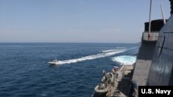 Iranian Islamic Revolutionary Guard Corps Navy (IRGCN) vessels are seem cclose to the guided-missile destroyer USS Paul Hamilton and other U.S. military ships in international waters of the north Arabian Gulf, April 15, 2020. (U.S. Navy photo)