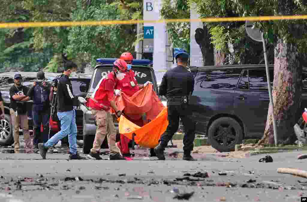 Police officer and rescue workers carry a body bag containing what is believed to be human remains outside a church where an explosion went off during a Palm Sunday Mass in Makassar, South Sulawesi, Indonesia.&#160;