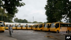 School buses are parked inside the premises of a deserted school compound in Srinagar, Indian controlled Kashmir, Aug. 19, 2019. 