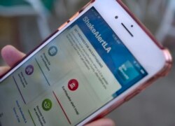 A mobile phone customer looks at an earthquake warning application on their phone in Los Angeles, Jan. 3, 2019. The app, called ShakeAlertLA, is available for download on Android and Apple phones.