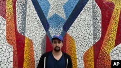 Actor and composer of Puerto Rican descent Lin Manuel Miranda stands in front of a mural in La Placita de Güisin, in Vega Alta, Puerto Rico, Nov. 7, 2017. 