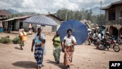 Des femmes déplacées par l'éruption du volcan Nyiragongo marchent dans la rue à Minova, à 50 kilomètres au sud de Goma, la capitale provinciale du Nord-Kivu, le 2 juin 2021.