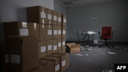 FILE - Boxes of voter registration forms are stacked in a space that the Iowa Democratic Party occupied near its headquarters in Des Moines, Iowa, Feb. 4, 2020.