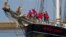 Dutch teens cheer on their schooner Wylde Swan after sailing home from the Caribbean across the Atlantic when coronavirus lockdowns prevented them flying, in the port of Harlingen, northern Netherlands, Sunday, April 26, 2020.