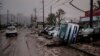 Typhoon-damaged cars sit on the street covered with mud, Oct. 14, 2019, in Hoyasu, Japan. 