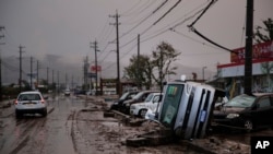 Typhoon-damaged cars sit on the street covered with mud, Oct. 14, 2019, in Hoyasu, Japan. Rescue crews dug through mudslides and searched near swollen rivers as they looked for those missing from typhoon Hagibis.