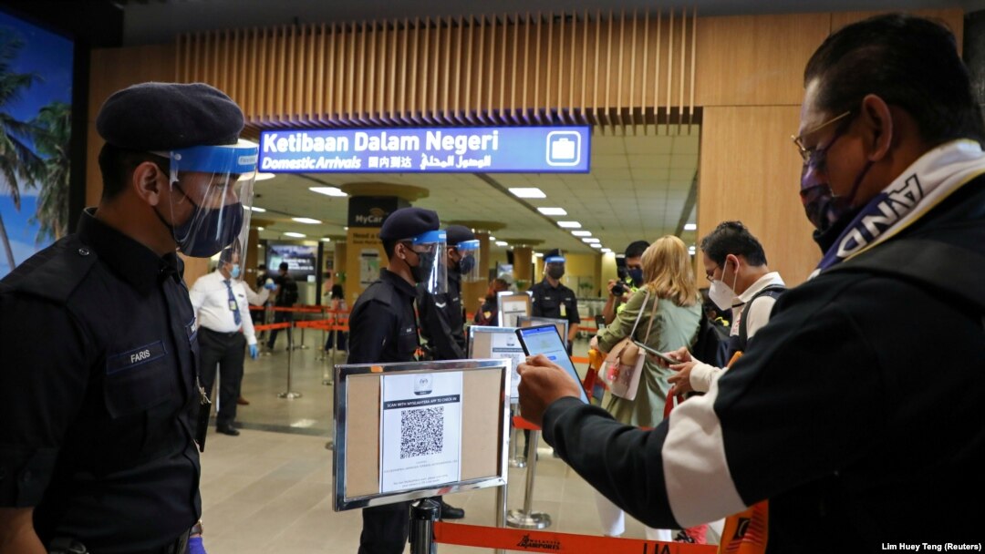 Seorang wisatawan memindai kode QR saat tiba di bandara menyusul pembukaan Langkawi untuk wisatawan domestik di tengah pandemi virus corona COVID-19) di Malaysia, 16 September 2021. (Foto: Lim Huey Teng/Reuters)