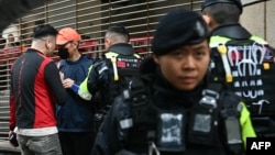 Police question a man outside the West Kowloon Magistrates' court in Hong Kong on Nov. 20, 2024. Pro-democracy Hong Kong tycoon Jimmy Lai took the stand in his collusion trial, testifying in court for the first time.