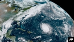 Hurricane Teddy, center, in the Atlantic; tropical depression 22, likely to be named Beta, left, in the Gulf of Mexico; the remnants of Paulette, top right; and Tropical Storm Wilfred, lower right, are seen in this image provided by NOAA, Sept. 18, 2020.